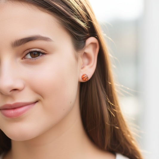 Close-up of an ear with basketball-stud earrings.