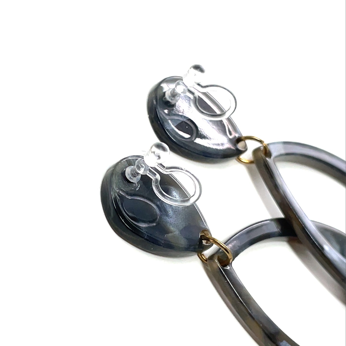 Pair of earrings with black and gold design on a white background