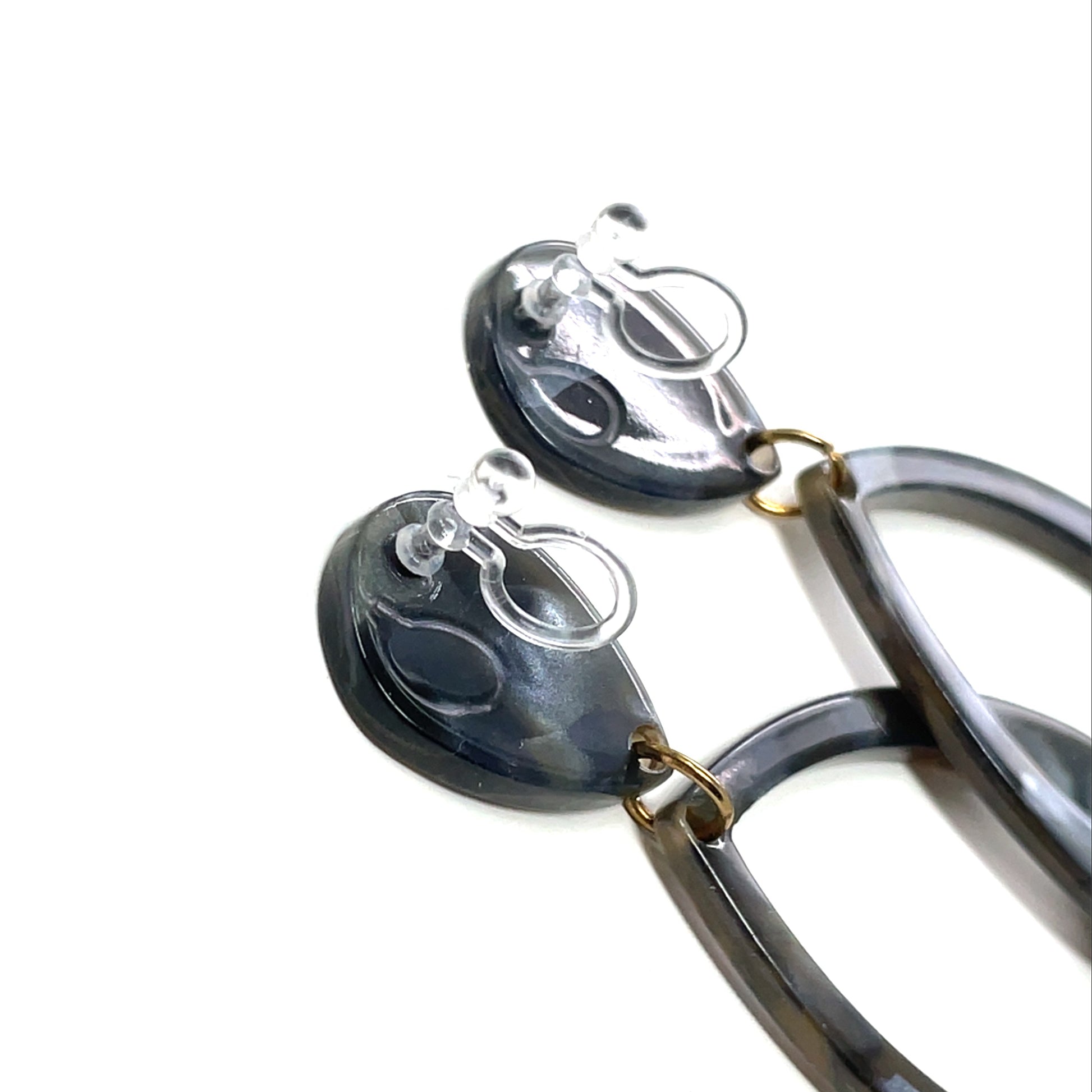 Pair of earrings with black and gold design on a white background