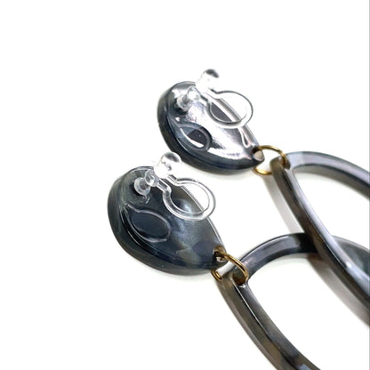 Pair of earrings with black and gold design on a white background
