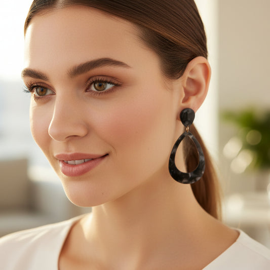 Woman wearing a black hoop earring with a blurred background