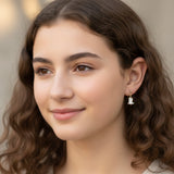 Close-up of an ear wearing a unicorn-shaped earring.