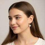 Close-up of an ear wearing a floral earring with a blurred background