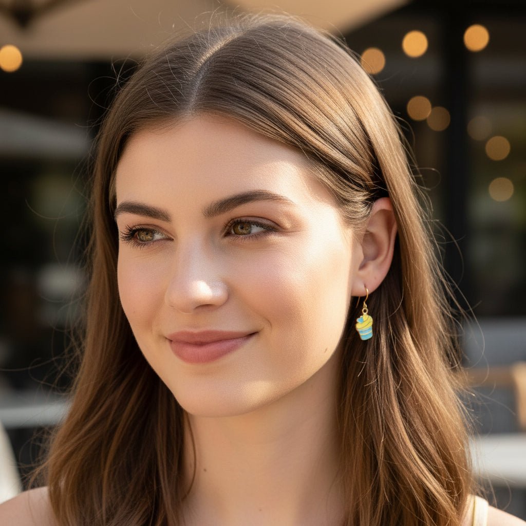 Close-up of an ear with a colorful earring, surrounded by blurred natural background