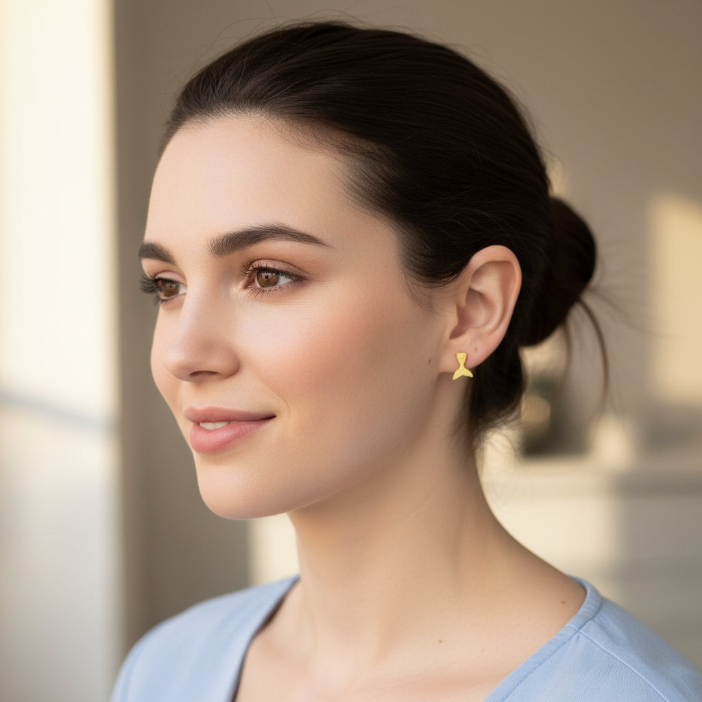 Close-up of an ear wearing a yellow mermaid tail earring with a blurred background