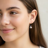 Close-up of an ear wearing a star-shaped earring with colorful stones.