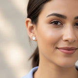 Close-up of an ear with a ghost-shaped earring and another small earring.
