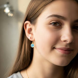 Close-up of an ear with a smiley face earring and another earring.