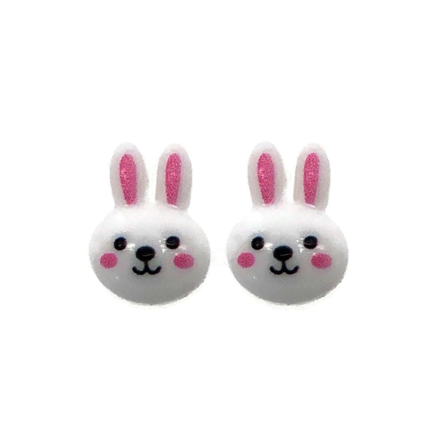A pair of white bunny face stud earrings with pink inner ears and black eyes, attached to clear posts.