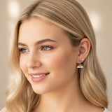 Close-up of an ear with rainbow-shaped earrings and additional jewelry.