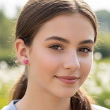 Close up of an ear wearing a small red heart earring