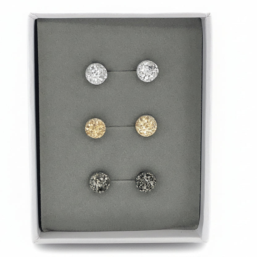 A set of three faux druzy stud earrings in varying colors displayed in a gift box.