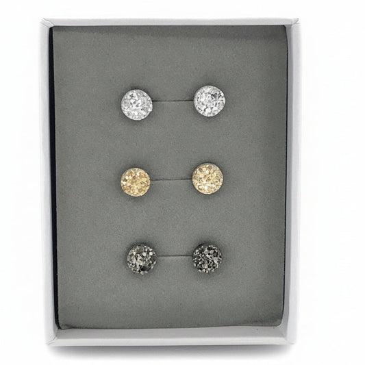 A set of three faux druzy stud earrings in varying colors displayed in a gift box.