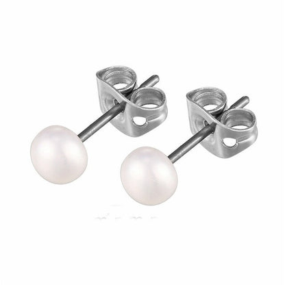 A pair of white freshwater pearl stud earrings attached to silver-colored titanium posts.