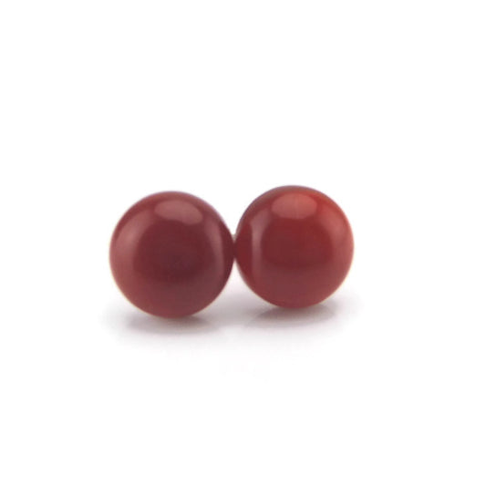 A pair of red agate stone stud earrings with a smooth finish, displayed against a white background.