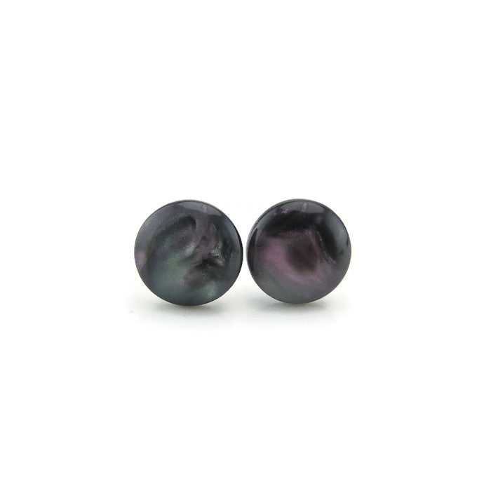 A pair of opalescent resin stud earrings with black featuring purple and green iridescence, displayed against a white background.