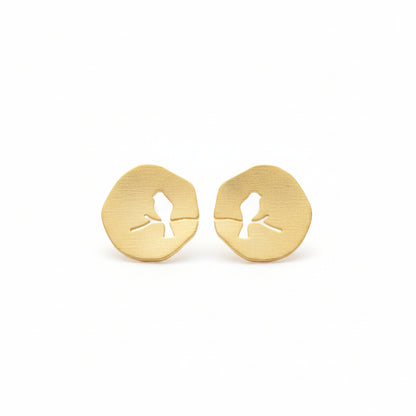 Gold-tone plated metal stud earrings with a bird design on a branch, resembling a lovebird, on a white background.