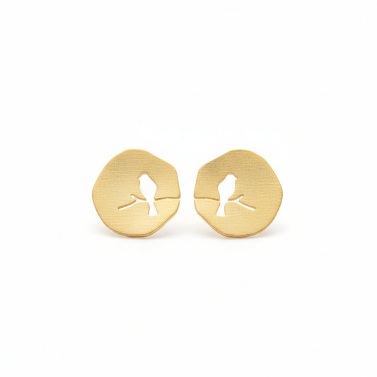 Gold-tone plated metal stud earrings with a bird design on a branch, resembling a lovebird, on a white background.