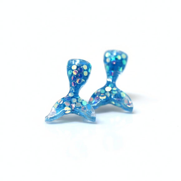 A pair of blue mermaid tail stud earrings adorned with glitter, displayed on a white background with a text overlay saying 'More Colors'.