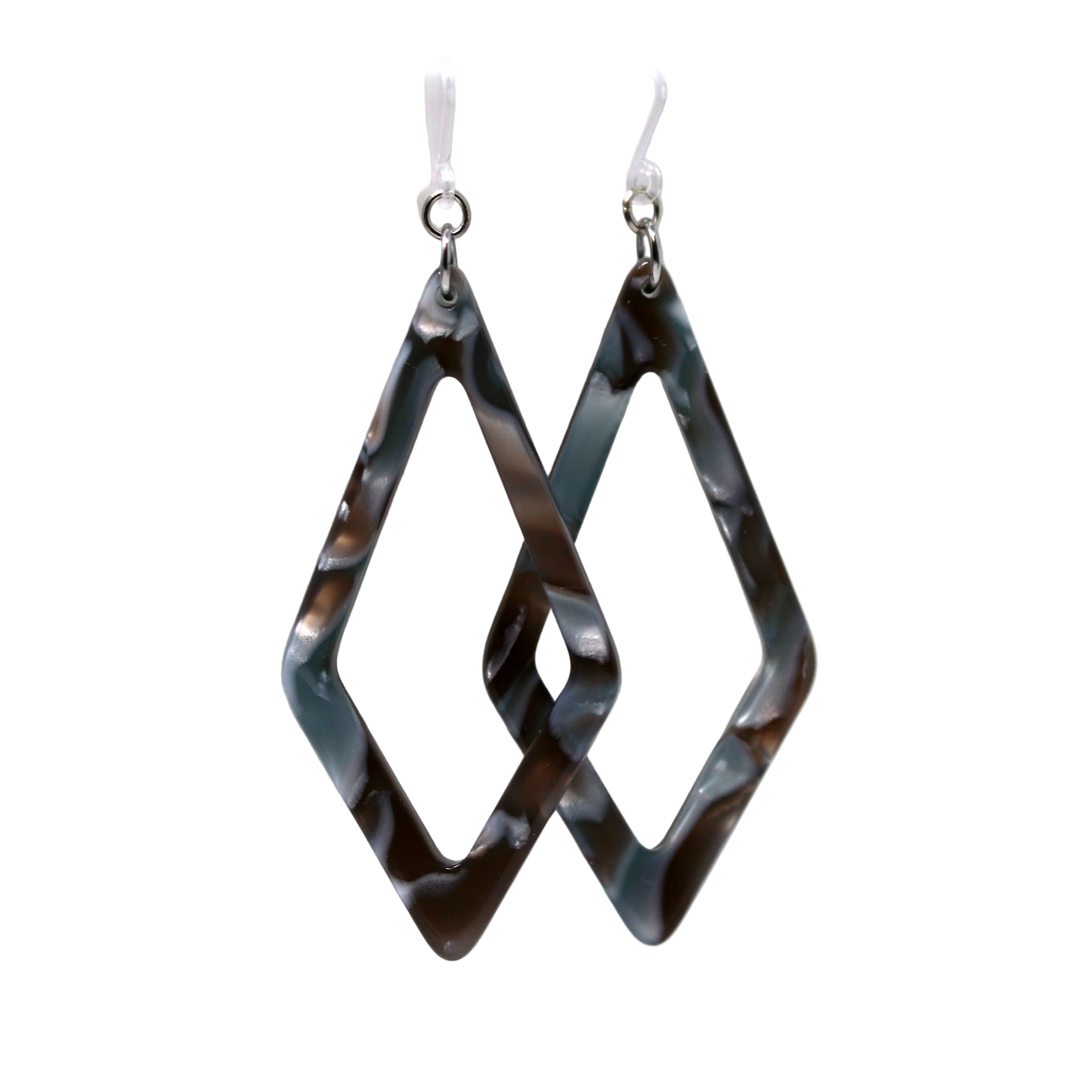 A pair of acrylic dangle earrings with a rhomboid pattern in blue and green shades, displayed on a white surface with a floral background.