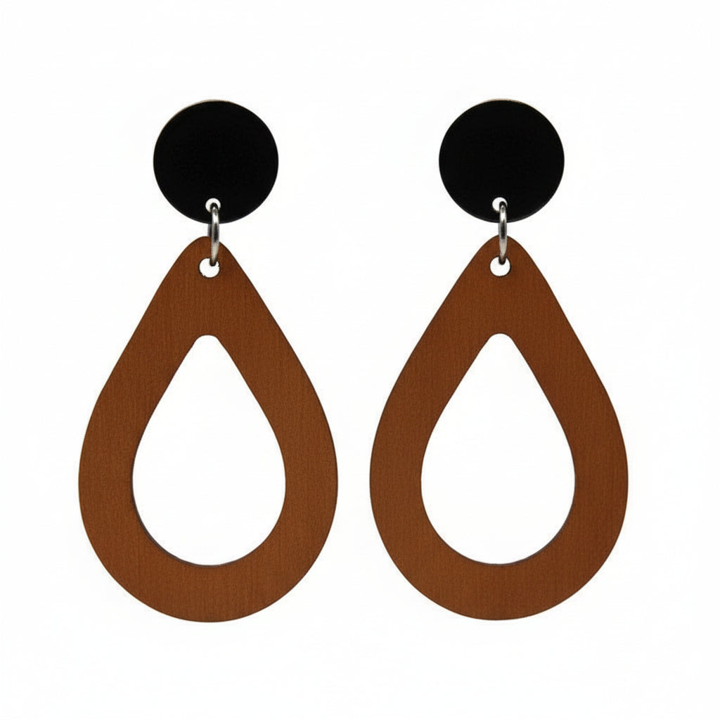 A pair of teardrop dangle earrings with an open design, made of wood attached to black acrylic circles, displayed on a gold-colored metal post.