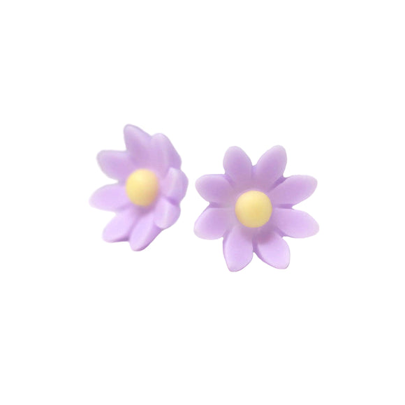A pair of purple flower stud earrings displayed on a white surface, with a text overlay saying 'More Colors'.