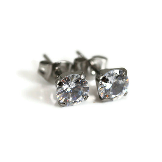 A pair of titanium 4-prong set cubic zirconia stud earrings.