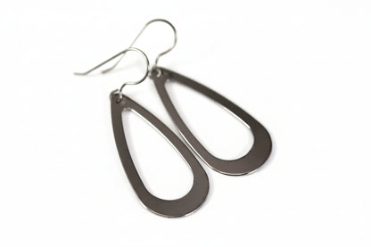 A pair of stainless steel teardrop dangle earrings with a visible hook.