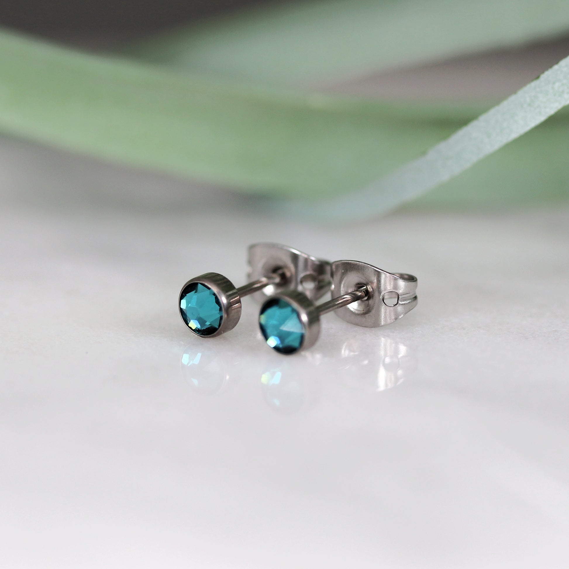 Titanium stud earrings, bezel set crystals, teal green