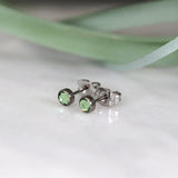 Titanium stud earrings, bezel set crystals, pale green
