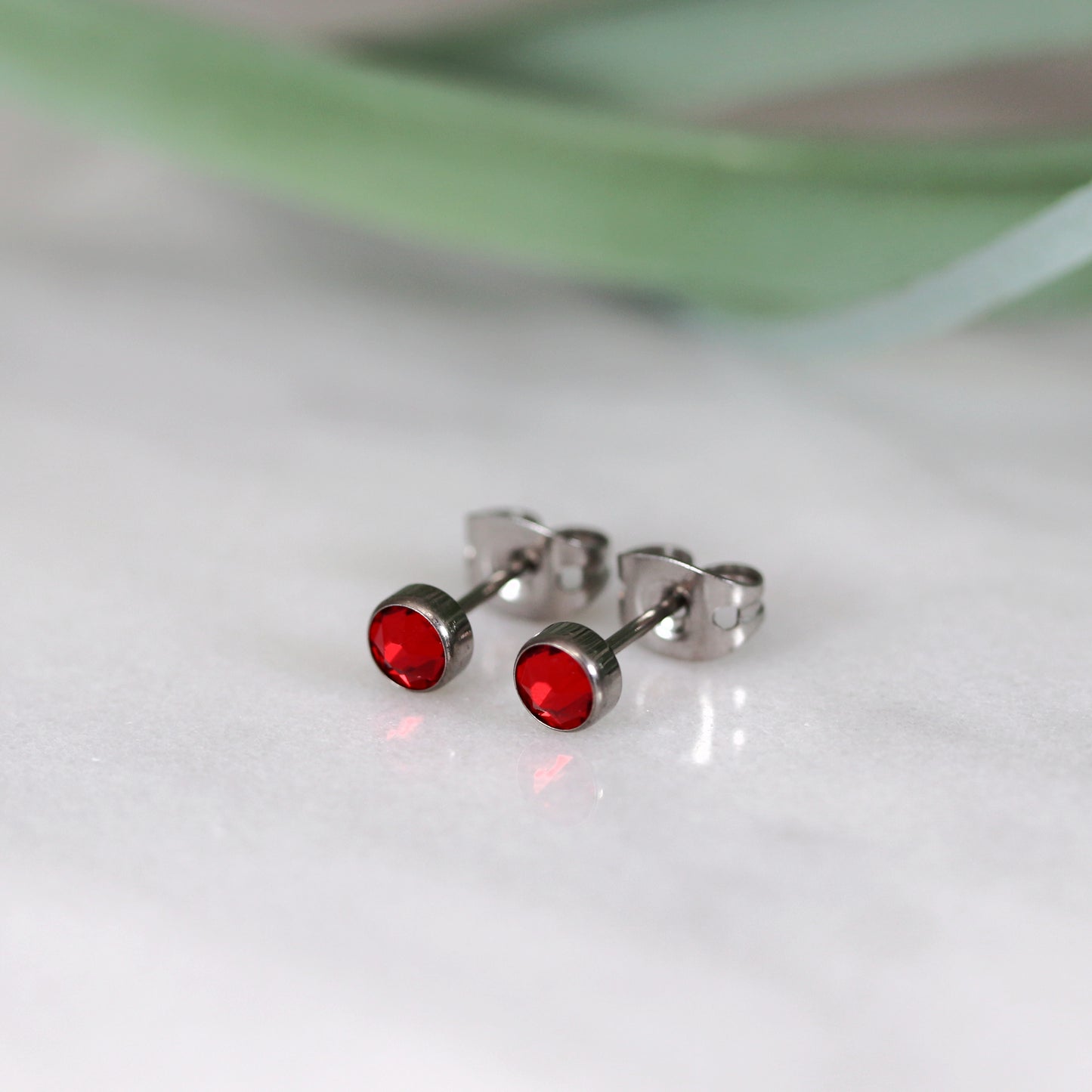 Titanium stud earrings, bezel set crystals, red