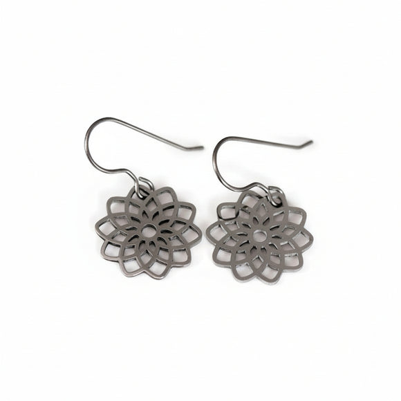 A pair of dangle earrings with a flower design, crafted from polished stainless steel, displayed against a white background.