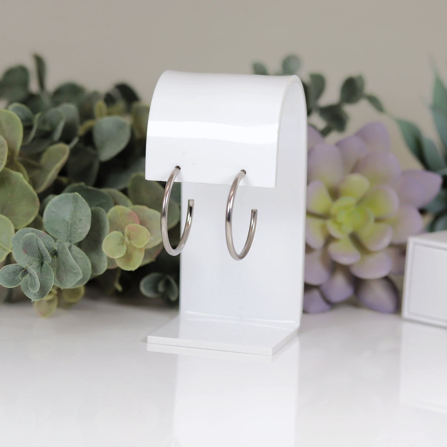 A pair of 30mm hoop stud earrings, one with a silver finish and the other with a gold plated copper finish.