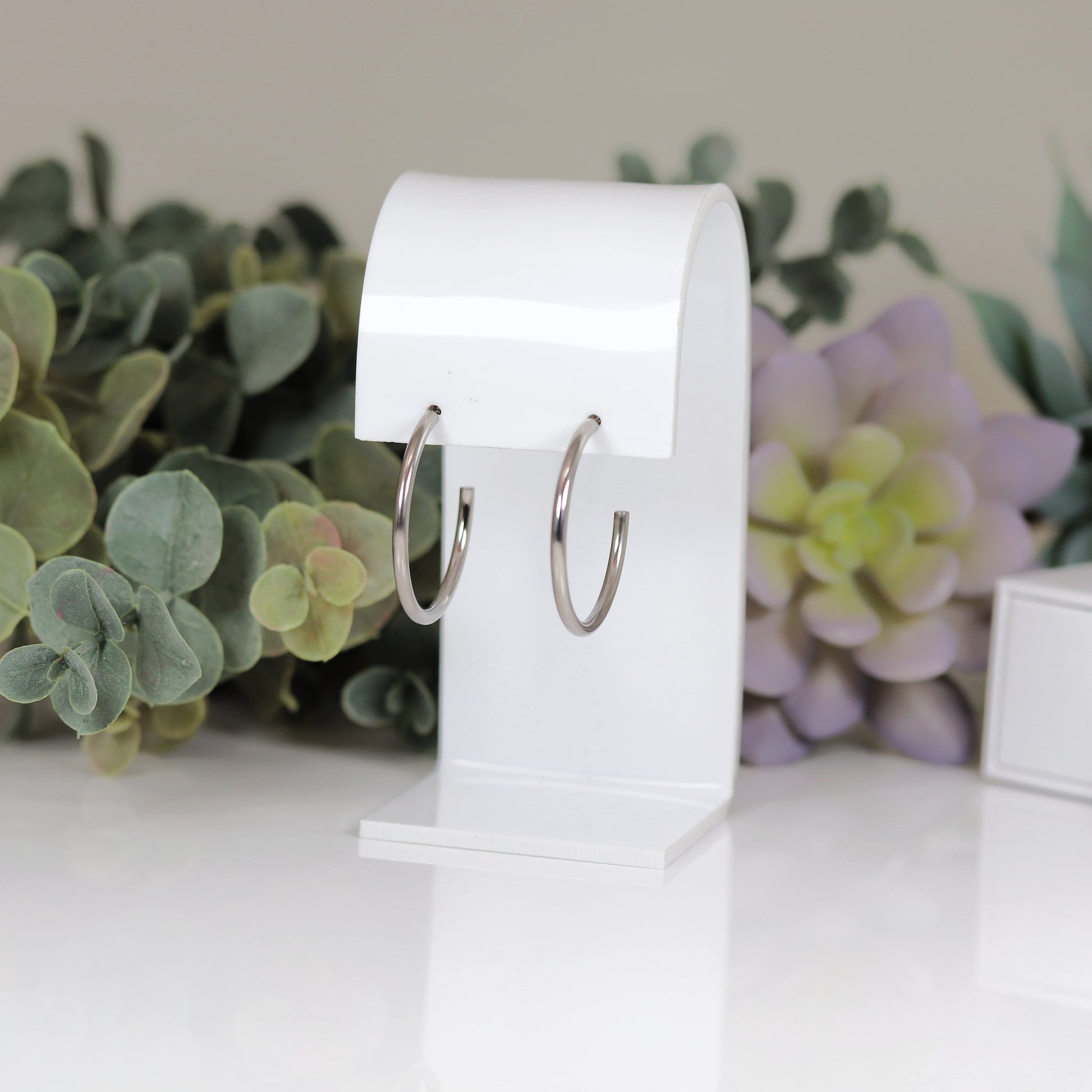 A pair of 30mm hoop stud earrings, one with a silver finish and the other with a gold plated copper finish.