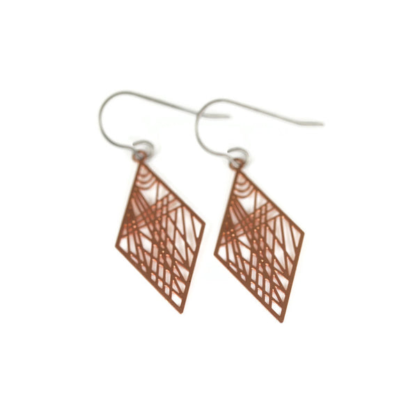 A pair of geometric dainty rhombus dangle earrings in rose gold color, displayed over a white textured surface.