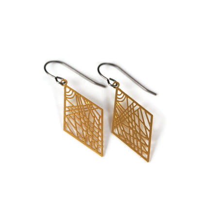 A pair of geometric dainty rhombus dangle earrings in silver color, displayed over a white textured surface.
