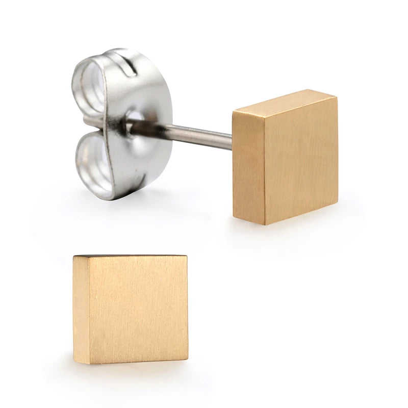 A pair of gold titanium square stud earrings laid on a white surface.