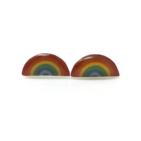 A pair of rainbow-colored stud earrings made of resin, with visible colors including red, orange, yellow, green, blue, and purple arches on a white background.